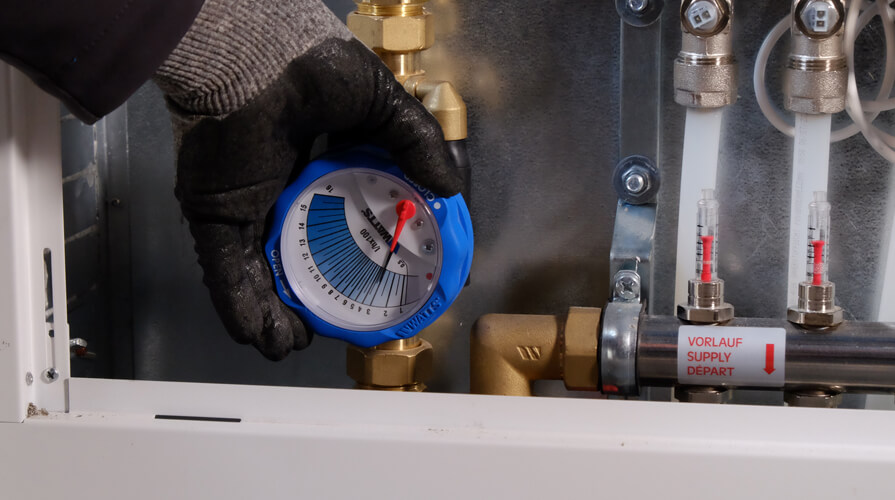An installer sets the flow rate with the iDROSET CF balancing valve in the heating circuit manifold of an underfloor heating system.