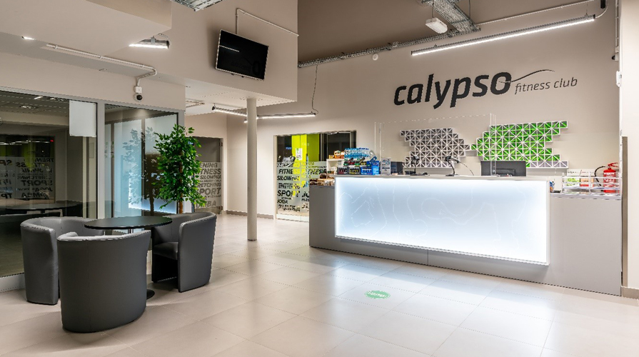 Стійка реєстрації фітнес-клубу Calypso із сучасним інтер'єром, яскравим світлодіодним підсвічуванням і зоною очікування. У клубі використовується термостатичний змішувальний клапан ULTRAMIX для підтримки безпечної температури води в душових.
