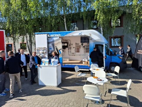 Mobilny showroom Watts – prezentacja rozwiązań grzewczych i rozmowy z gośćmi na zewnątrz podczas targów.