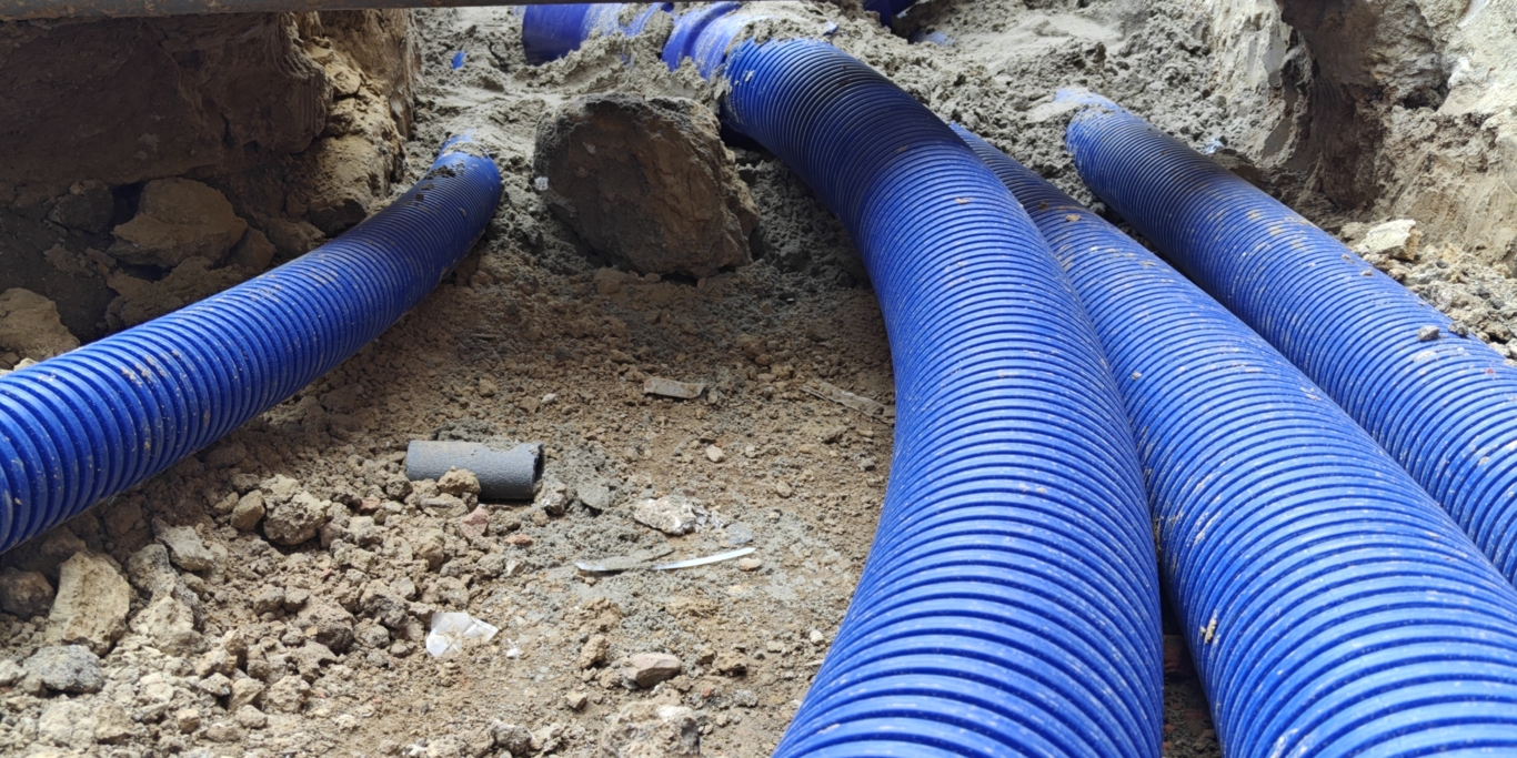 Close-up van geïnstalleerde WATTS Microflex voorgeïsoleerde buizen in een sleuf op een bouwplaats